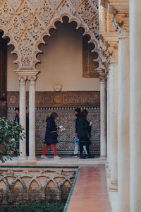 Rear view of people in front of historical building