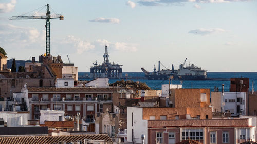 Buildings in city against cloudy sky