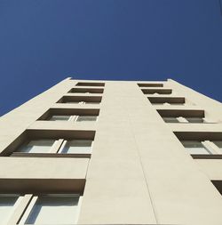 Low angle view of modern building against clear blue sky