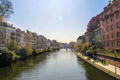 Canal amidst buildings in city against sky