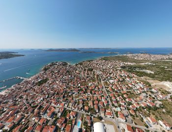 High angle view of townscape by sea against clear sky