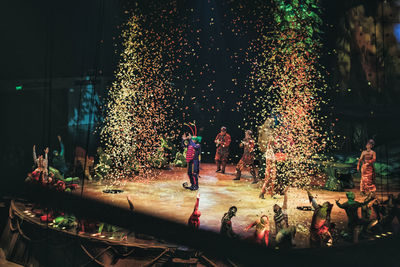 Full length of people on stage standing amidst confetti