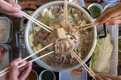 Cropped hands of friends having food