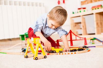 Boy playing with toy car on floor