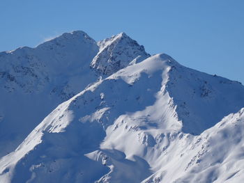 Close-up of snowcapped mountain against clear sky