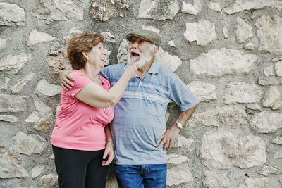 Friends standing against wall