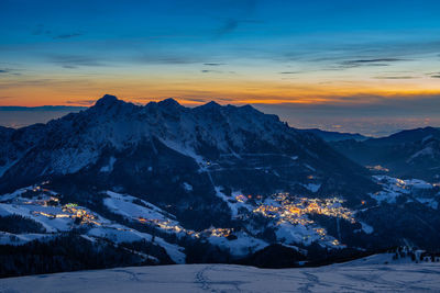 Snowy mountain village at sunset