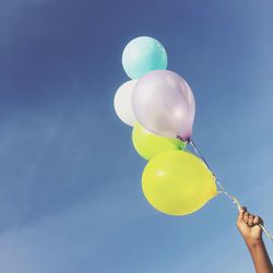 Low angle view of balloons against blue sky