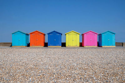 Colorful beach huts against clear blue sky