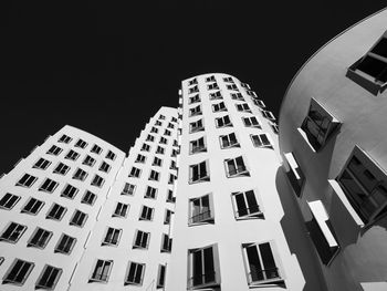 Low angle view of modern buildings against clear sky at night