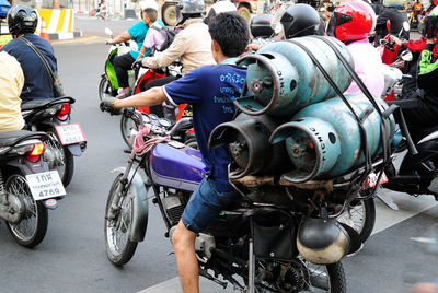 Man carrying gas cylinders on motorcycle
