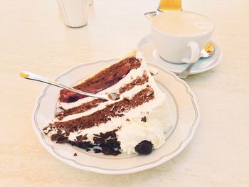 High angle view piece of cake and coffee cup on table