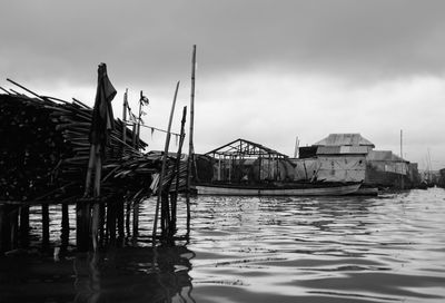 Wooden posts in sea against sky