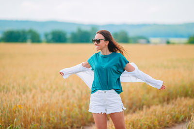 Woman wearing sunglasses standing on field