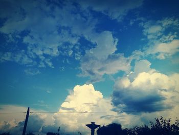 Low angle view of silhouette trees against blue sky