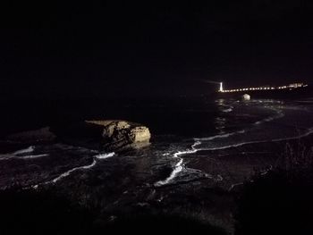 Scenic view of illuminated sea against sky at night