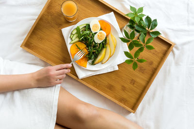 Midsection of woman having breakfast on bed