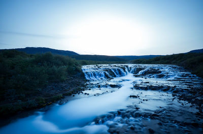 Scenic view of waterfall against sky