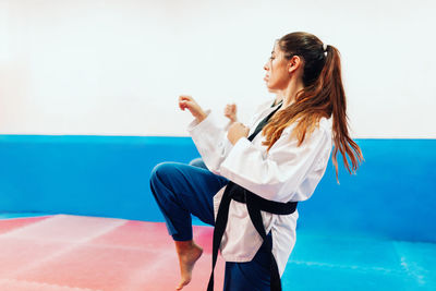 Young woman with instructor practicing martial arts