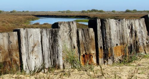 Wooden fence in farm against sky