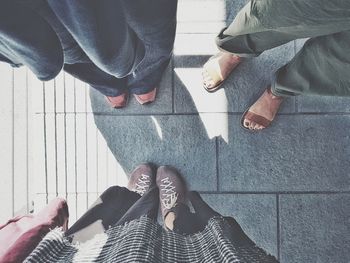 Low section of people standing on tiled floor