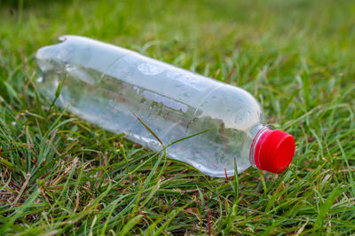 Close-up of water bottle on grass
