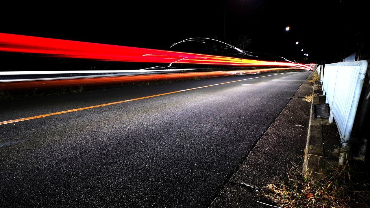 BLURRED MOTION OF LIGHT TRAILS ON ROAD AT NIGHT