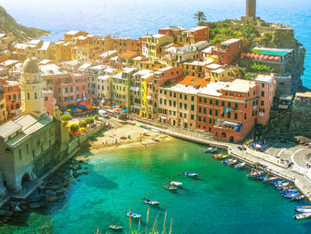 High angle view of boats moored at sea by town in cinque terre