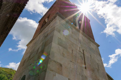 Low angle view of cross on building against sky