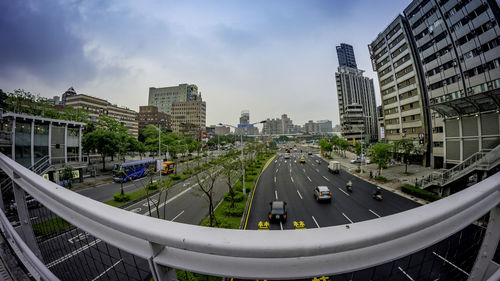 Cars on road in city against sky