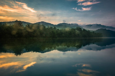 Scenic view of lake by mountains against sky