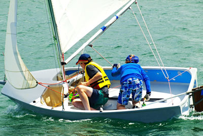 People in boat sailing on sea