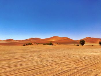 Scenic view of desert against clear blue sky