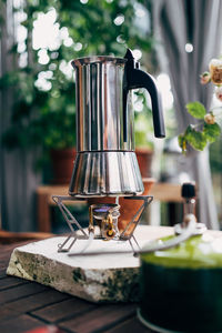 Close-up of espresso maker on camping stove on table