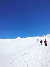 Scenic view of snow covered mountain against clear blue sky