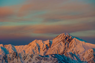 Scenic view of snowcapped mountains against sky during sunrise