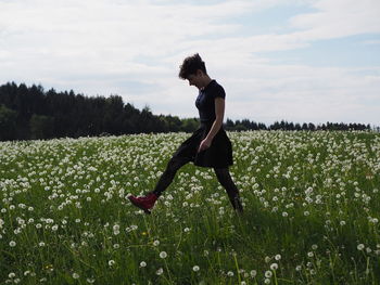 Side view of woman on field against sky