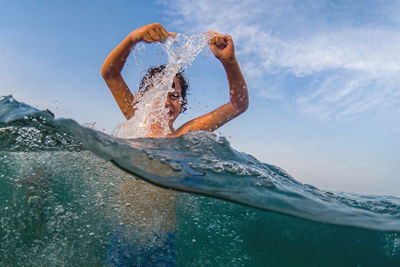 Woman swimming in sea against sky