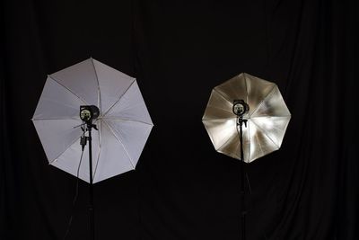 Umbrellas with lighting equipment against black background