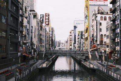 Canal amidst buildings against sky in city