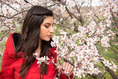 Young woman with cherry blossom on tree