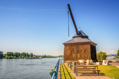 Pier over river against clear blue sky