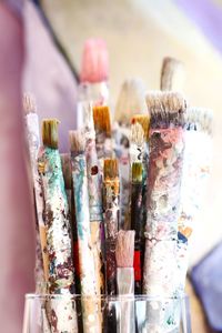 Close-up of messy paint brushes at table