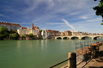 Arch bridge over river against buildings in city