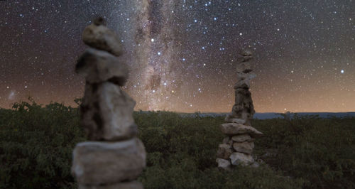 Rocks on field against sky at night