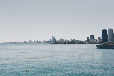 River and cityscape against clear sky