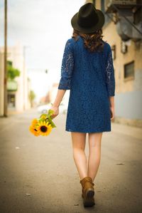 Rear view of woman standing by building