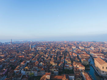 Aerial view of cityscape against blue sky