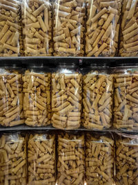 Full frame shot of spring rolls in glass jars on shelves at store