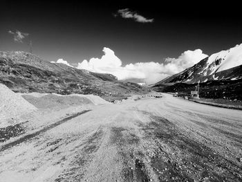 Scenic view of road by mountains against sky